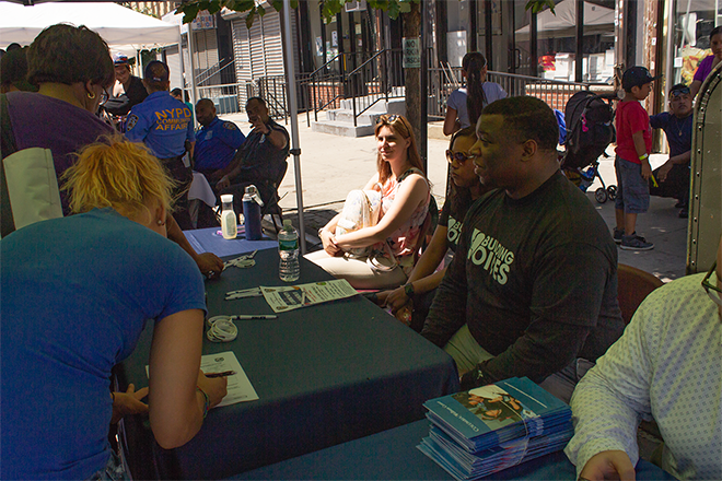 Representatives from Turner Construction, Kevin Chase, Brittney Parkinson, and Kimberly Sauer, speak with Harlem residents about construction work opportunities on the new Manhattanville Campus.