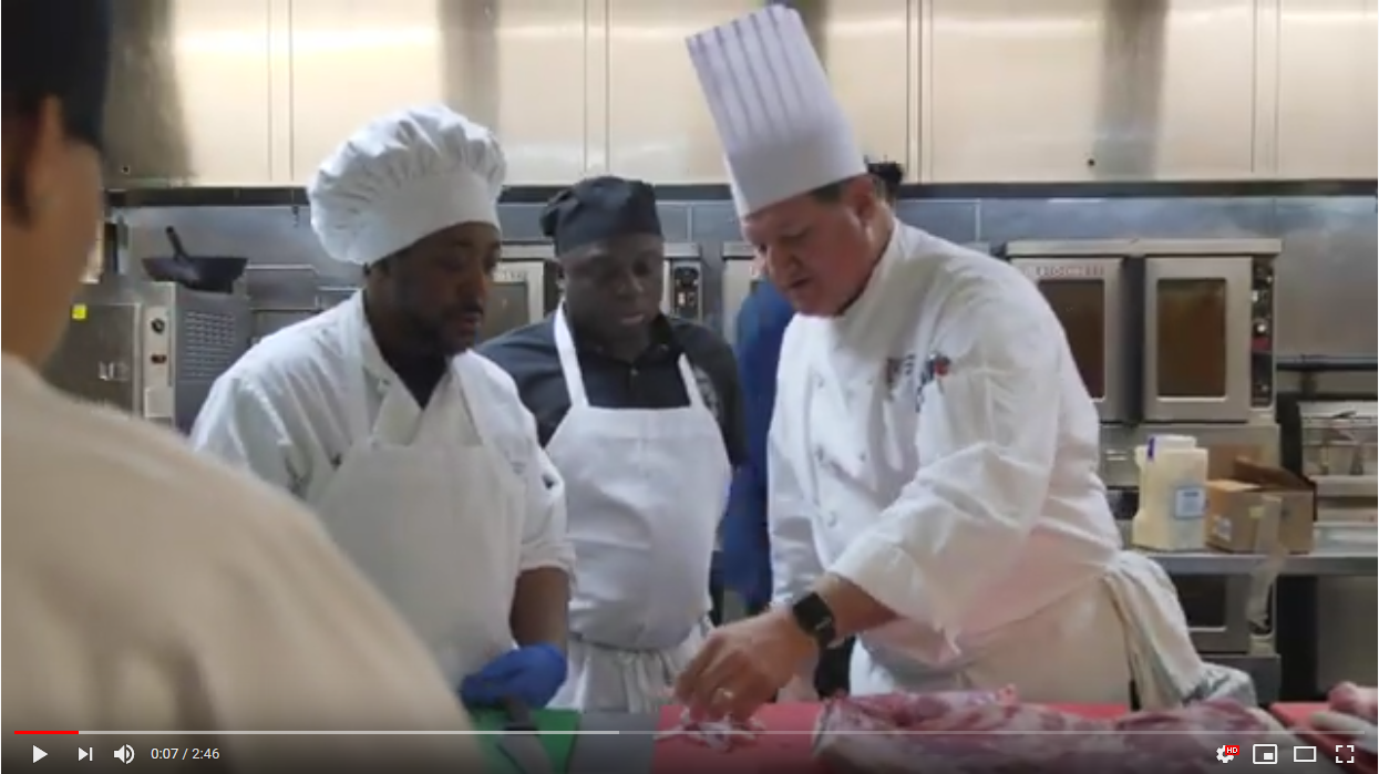 Screenshot of the Culinary Training with the Chefs from the Culinary Institute of America video with chefs looking at a cut of meat on a cutting board