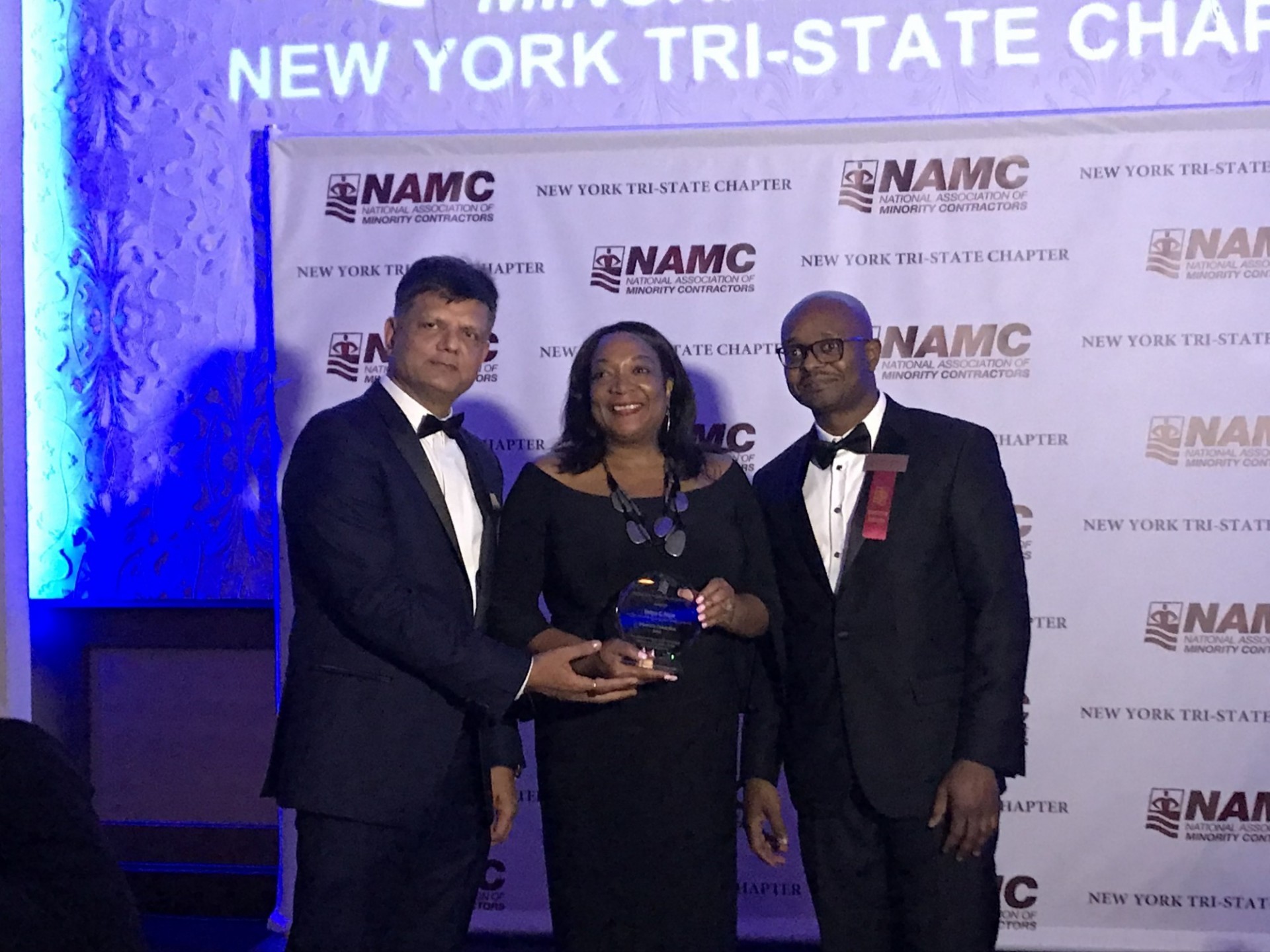 Tanya Pope (center) accepting the Diversity Champion Award from NAMC-NY President Nayan Parikh (left) and Andrew Fisher, an executive member of the organization.