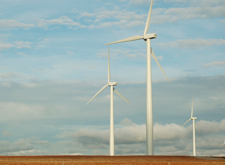 Grant Wind Facility in Central Oklahoma provides 20% of Columbia's purchase for renewable energy. Three large wind turbines against a blue and cloudy sky