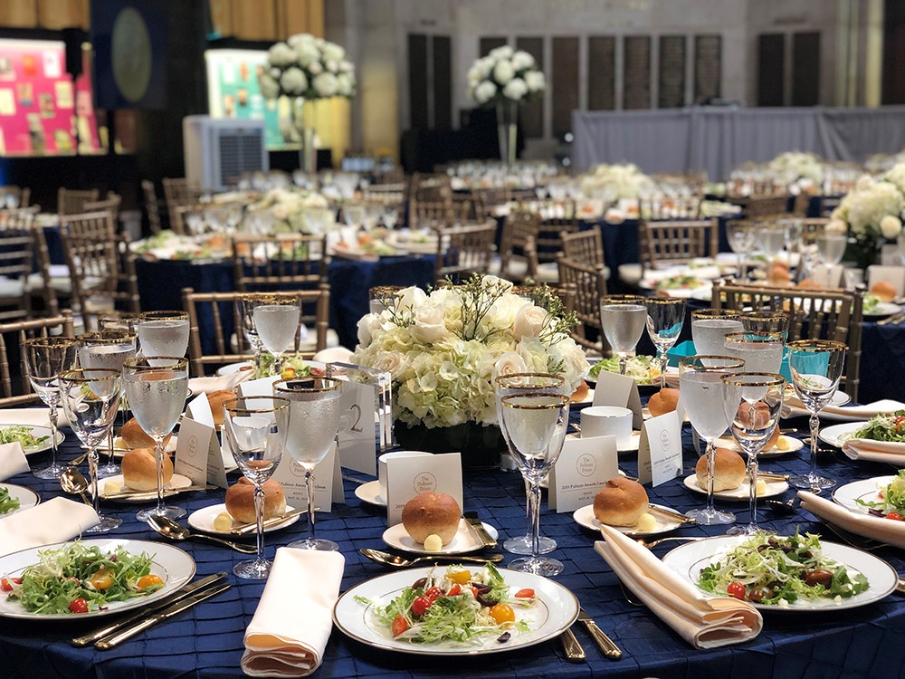 A table set up with flowers and place settings with food and drinks