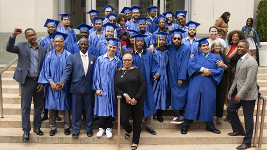 Graduates of the new pre-apprenticeship program pose outside Uris Hall