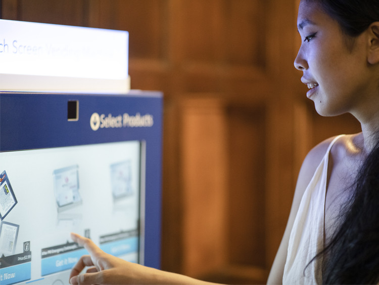 A female student selecting an item on the touch screen of the emergency contraception vending machine