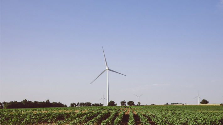 A wind farm with a large turbine in the foreground and several turbines in the distance